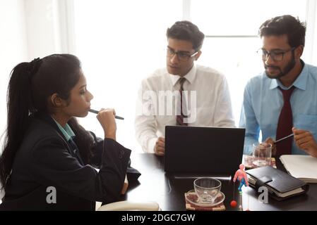 Junge und energische Untergebene diskutieren im indischen Büro mit weiblicher Chefin. Indisches Unternehmen Stockfoto