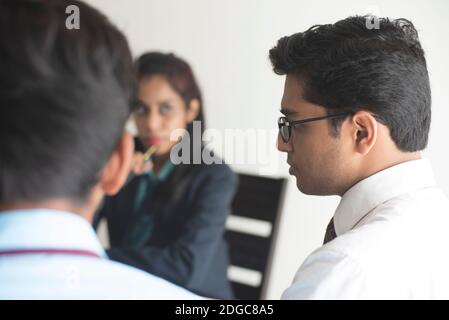 Junge und energische Untergebene diskutieren im indischen Büro mit weiblicher Chefin. Indisches Unternehmen Stockfoto