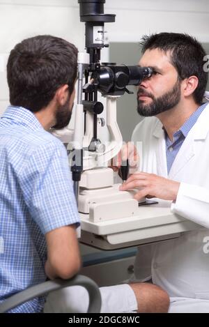 Männlicher Arzt Augenarzt überprüft die Augen Vision von schönen jungen Mann in der modernen Klinik. Arzt und Patient in Ophthalmolo Stockfoto