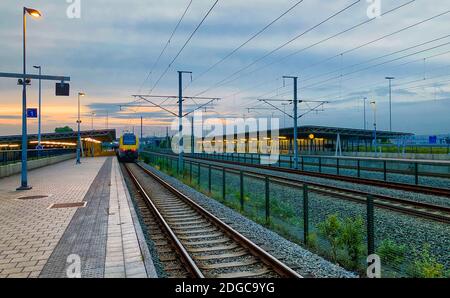 Brecht, Belgien - Juni 2019: Ein Pendlerzug im Bahnhof Noorderkempen in Brecht bei Sonnenaufgang Stockfoto