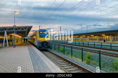 Brecht, Belgien - Juni 2019: Ein Pendlerzug im Bahnhof Noorderkempen in Brecht bei Sonnenaufgang Stockfoto