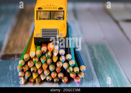 Spielzeug gelben Bus auf Bündel von Buntstiften . Stockfoto