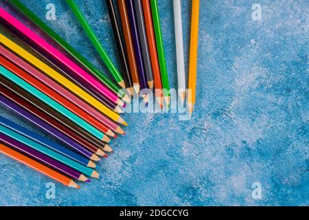 Bunte Bleistifte auf blauem Hintergrund. Draufsicht Stockfoto