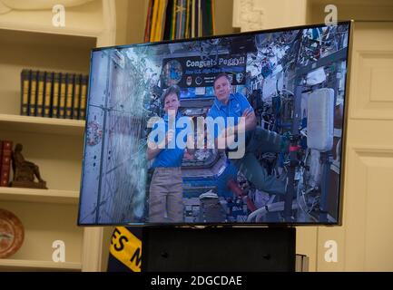 24. April 2017 - die NASA-Astronauten Peggy Whitson und Jack Fischer erscheinen auf einem Bildschirm, während Präsident Donald Trump eine Videokonferenz mit dann an Bord der Internationalen Raumstation im Oval Office im Weißen Haus veranstaltet. (Molly Riley/Polaris) Stockfoto