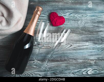 Herz, Champagner und zwei Gläser auf Holzgrund. Stockfoto