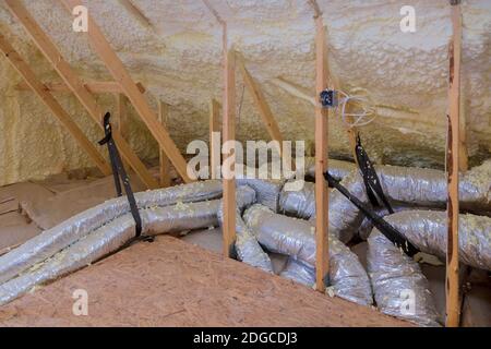 Haus Lüftungsrohre in Silber Isoliermaterial auf dem Dachboden Stockfoto