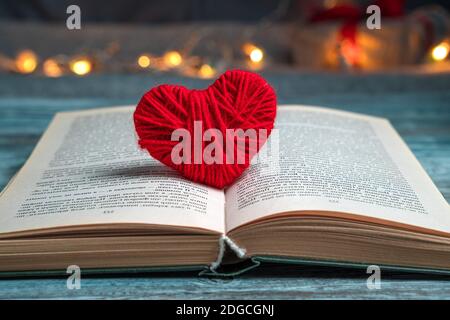 Roter Faden in einem offenen Buch auf festlichem Hintergrund. Stockfoto