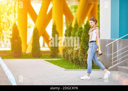 Junges Mädchen, das an einem Sommertag die Treppe hinunter kommt. Volle Höhe Stockfoto