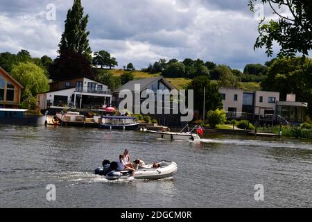 Familie auf einem kleinen Motorboot, Kreuzfahrt entlang der Themse, Bourne End, Buckinghamshire, Großbritannien. Zwei Hunde an Bord. Stockfoto