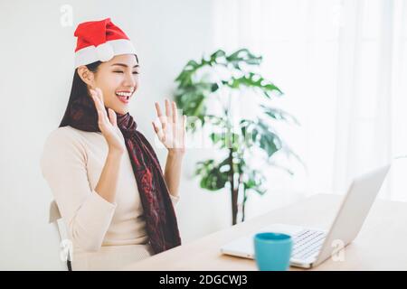 Glückliche junge Frau mit Laptop in Videoanruf und feiern weihnachten Stockfoto
