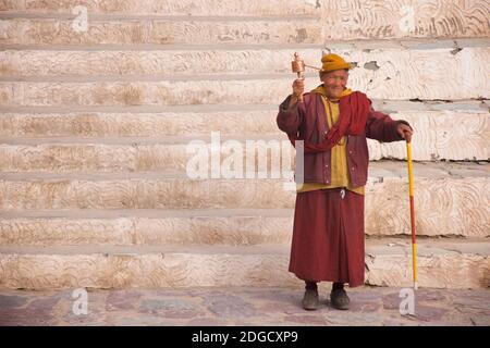 Portrait eines freundlichen, älteren Mönchs mit Sonnenbrille und Gebetrad im Hemis Kloster, Hemis, Ladakh, Jammu und Kashmir, Indien Stockfoto