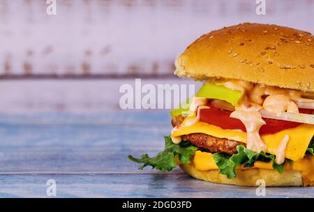 Cheeseburger mit geschmolzenem Käse auf einem weißen Tisch. Stockfoto