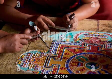 Mönche im Lamayuru Kloster, Ladakh Schaffung eines Mandala von farbigem Sand. Lamayouro, Ladakh, Jammu und Kaschmir, Indien. Ein Sandmandala wird ritualistisch abgebaut, sobald es abgeschlossen ist und seine begleitenden Zeremonien und das Betrachten beendet sind, um den buddhistischen doktrinären Glauben an die vorübergehende Natur des materiellen Lebens zu symbolisieren. Stockfoto