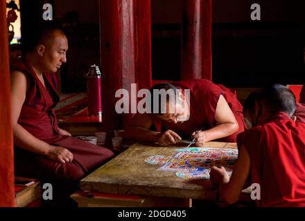 Mönche im Lamayuru Kloster, Ladakh Schaffung eines Mandala von farbigem Sand. Lamayouro, Ladakh, Jammu und Kaschmir, Indien. Ein Sandmandala wird ritualistisch abgebaut, sobald es abgeschlossen ist und seine begleitenden Zeremonien und das Betrachten beendet sind, um den buddhistischen doktrinären Glauben an die vorübergehende Natur des materiellen Lebens zu symbolisieren. Stockfoto