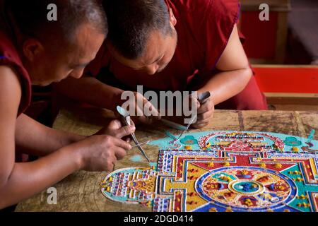 Mönche im Lamayuru Kloster, Ladakh Schaffung eines Mandala von farbigem Sand. Lamayouro, Ladakh, Jammu und Kaschmir, Indien. Ein Sandmandala wird ritualistisch abgebaut, sobald es abgeschlossen ist und seine begleitenden Zeremonien und das Betrachten beendet sind, um den buddhistischen doktrinären Glauben an die vorübergehende Natur des materiellen Lebens zu symbolisieren. Stockfoto