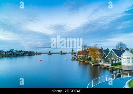 Blick in die Dämmerung auf typisch holländische Häuser mit Windmühlen und die Fluss Zaan Stockfoto