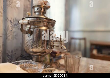 Im Dorfhaus Küche auf dem Tisch ist ein alter samovar Und facettiertem Glas Stockfoto