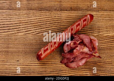 Gebratene Wurst und Speck auf einem Holzbrett Stockfoto