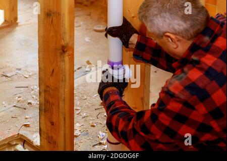 Klempner verbinden Kunststoffrohre mit Leimzement für Abflüsse unter Konstruktion Stockfoto