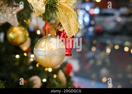 Weihnachtsbaum Spielzeug in Form einer goldenen Kugel An den Ästen hängen Stockfoto