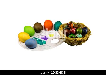 Bemalte Eier mit einem Strohnest auf weißem Hintergrund, Feier von Ostern Stockfoto