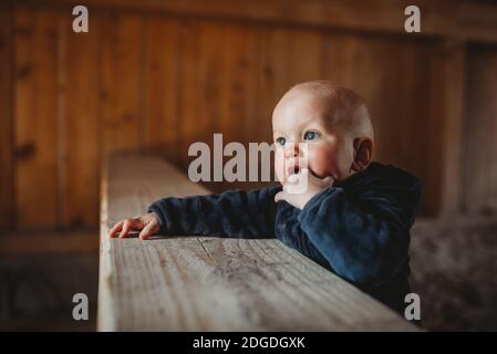 Baby Junge mit blauen Augen setzen Finger in den Mund Zapfen Draußen Stockfoto