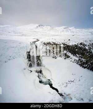 Luftlandschaft des Wasserfalls fließt von der Klippe im Winter in Gebirge in Island Stockfoto