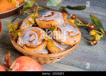 Hausgemachte Zimtrollen mit weißer Glasur und Apfel. Stockfoto