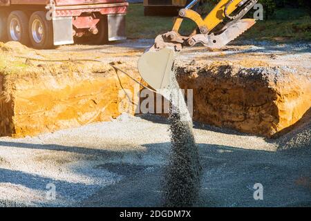 Nahaufnahme Bagger Arbeiten auf einer Baustelle, Bagger Eimer Ebenen Kies auf dem Fundament des Gebäudes Stockfoto