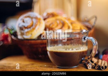 Zimtrollen mit Kaffee auf Holztisch Stockfoto