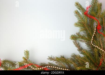 Winterurlaub Weihnachten Zusammensetzung Hintergrund.Rahmen aus Weihnachtsbaum Tannenzweige und rot und silber weihnachtsdekoration auf grau gemacht. Stockfoto