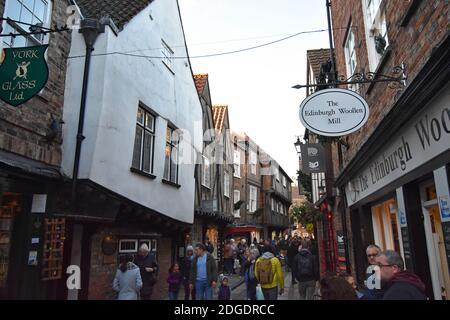 The Shambles, eine alte Straße in York, England, mit überhängenden Fachwerkhäusern. Touristen und Einkäufer füllen die kleine enge mittelalterliche Straße. Stockfoto