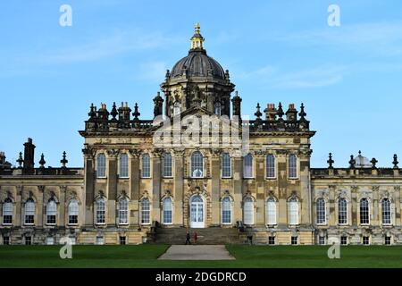 The South Front of Castle Howard, ein historisches Herrenhaus in North Yorkshire, England. Zwei Besucher gehen an einer Treppe vorbei, die zu einem hinteren Eingang führt. Stockfoto