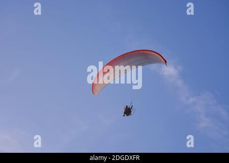 Paramotor (Powered Paraglider) Mit Rot-Weißem Parachute Flying In Sky, Extreme Sport. Stockfoto