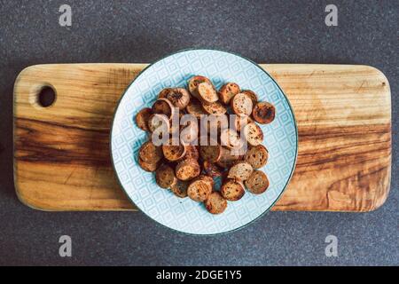 Gesunde pflanzliche Rezeptur Konzept, vegane Wurst in Salami-Scheiben geschnitten und Pfanne gebraten mit gerissenem Pfeffer auf der Oberseite Stockfoto