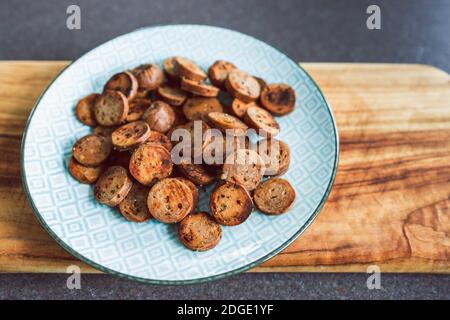 Gesunde pflanzliche Rezeptur Konzept, vegane Wurst in Salami-Scheiben geschnitten und Pfanne gebraten mit gerissenem Pfeffer auf der Oberseite Stockfoto