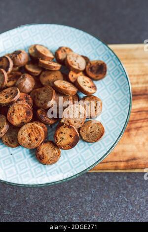 Gesunde pflanzliche Rezeptur Konzept, vegane Wurst in Salami-Scheiben geschnitten und Pfanne gebraten mit gerissenem Pfeffer auf der Oberseite Stockfoto