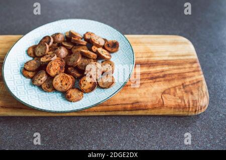 Gesunde pflanzliche Rezeptur Konzept, vegane Wurst in Salami-Scheiben geschnitten und Pfanne gebraten mit gerissenem Pfeffer auf der Oberseite Stockfoto