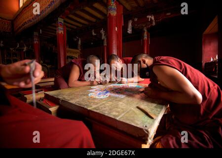 Mönche im Lamayuru Kloster, Ladakh Schaffung eines Mandala von farbigem Sand. Lamayouro, Ladakh, Jammu und Kaschmir, Indien. Ein Sandmandala wird ritualistisch abgebaut, sobald es abgeschlossen ist und seine begleitenden Zeremonien und das Betrachten beendet sind, um den buddhistischen doktrinären Glauben an die vorübergehende Natur des materiellen Lebens zu symbolisieren. Stockfoto