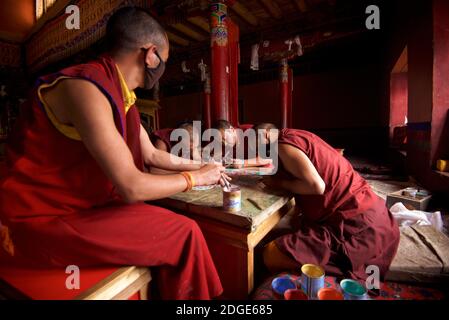 Mönche im Lamayuru Kloster, Ladakh Schaffung eines Mandala von farbigem Sand. Lamayouro, Ladakh, Jammu und Kaschmir, Indien. Ein Sandmandala wird ritualistisch abgebaut, sobald es abgeschlossen ist und seine begleitenden Zeremonien und das Betrachten beendet sind, um den buddhistischen doktrinären Glauben an die vorübergehende Natur des materiellen Lebens zu symbolisieren. Stockfoto