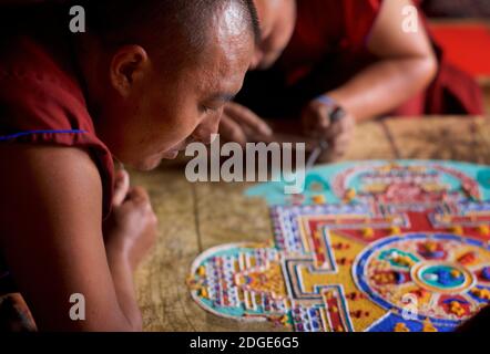 Mönche im Lamayuru Kloster, Ladakh Schaffung eines Mandala von farbigem Sand. Lamayouro, Ladakh, Jammu und Kaschmir, Indien. Ein Sandmandala wird ritualistisch abgebaut, sobald es abgeschlossen ist und seine begleitenden Zeremonien und das Betrachten beendet sind, um den buddhistischen doktrinären Glauben an die vorübergehende Natur des materiellen Lebens zu symbolisieren. Stockfoto