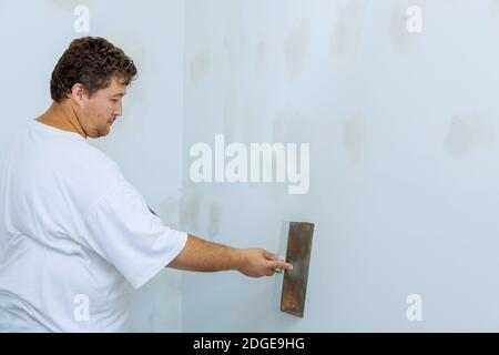 Arbeitnehmer richtet mit einem Spachtel Wand Stockfoto