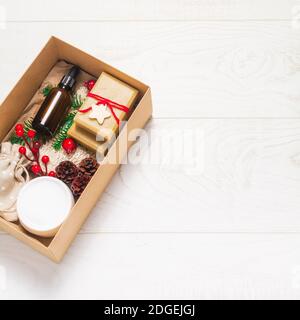 Schöne Geschenk-Box mit Bio-Kosmetik auf Holzhintergrund. Glas, Holzdekorationen. Zero Waste Weihnachtskonzept. Flach liegend, Draufsicht Stockfoto