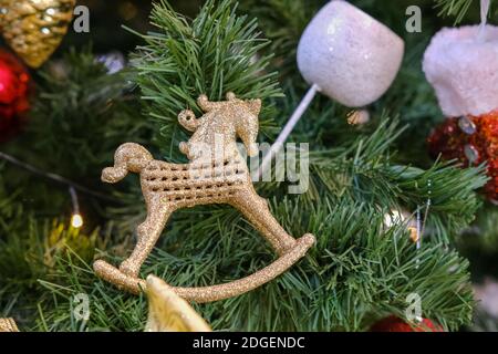 Weihnachtsbaum Spielzeug in Form eines goldenen Pferdes An den Ästen hängen Stockfoto