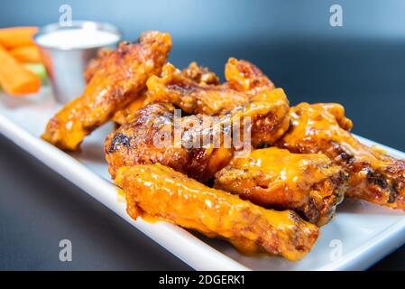 Köstliche süße würzige Hähnchenflügel auf einem Teller gestapelt macht den Mund Wasser und den Magen knurren. Stockfoto