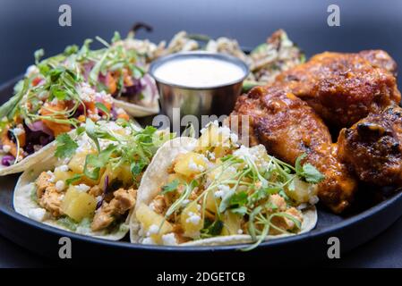 Köstliche Vorspeise Sampler Teller mit Huhn und Steak Tacos, Poppers und Büffelflügel macht den Mund Wasser und den Magen knurren. Stockfoto