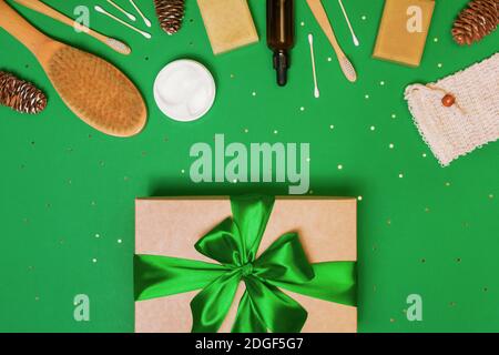 Geschenkbox mit Naturkosmetik für gesunde Haut und Gesicht auf grünem Hintergrund mit Konfetti. Umweltfreundliches Geschenk zu weihnachten, Geburtstag. Flach liegend Stockfoto