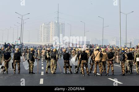 Neu Delhi. Dezember 2020. Indisches Polizeipersonal steht Wache auf der Delhi-Meerut Schnellstraße während eines Protests gegen die neuen Agrargesetze in Indien, 8. Dezember 2020. Die landesweite Stilllegung, die von Bauern aus dem ganzen Land gefordert wurde, ging am Dienstag friedlich vonstatte, wobei einige Störungen im Straßen- und Schienenverkehr aus einigen Teilen des Landes gemeldet wurden. Die Schließung wurde von den Bauern während ihrer anhaltenden Proteste gegen die drei neuen Agrargesetze, die kürzlich von der Regierung erlassen wurden, gefordert. Quelle: Partha Sarkar/Xinhua/Alamy Live News Stockfoto