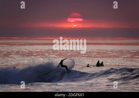 San Diego, Kalifornien, USA. Dezember 2020. Ein Surfer reitet eine Welle bei Sonnenuntergang am Windansea Beach in La Jolla während eines High Surf Advisory. Kredit: K.C. Alfred/ZUMA Wire/Alamy Live News Stockfoto