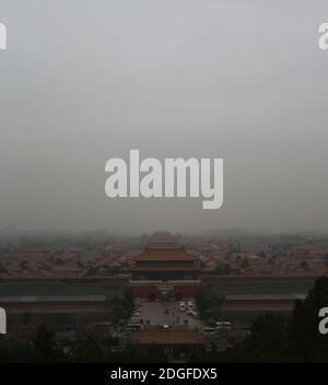 --FILE--Blick nach unten aus Wanchun Pavillon im Jingshan Park, die Verbotene Stadt ist in Smog gehüllt, und die gelbe Warnung für schwere Luftverschmutzung ist s Stockfoto